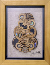 A thick wooden photoframe with a wooden laser engraved Tiki inside. It has several elements of inlaid Paua shell like the eyes. This is protected by a clear perspex front window